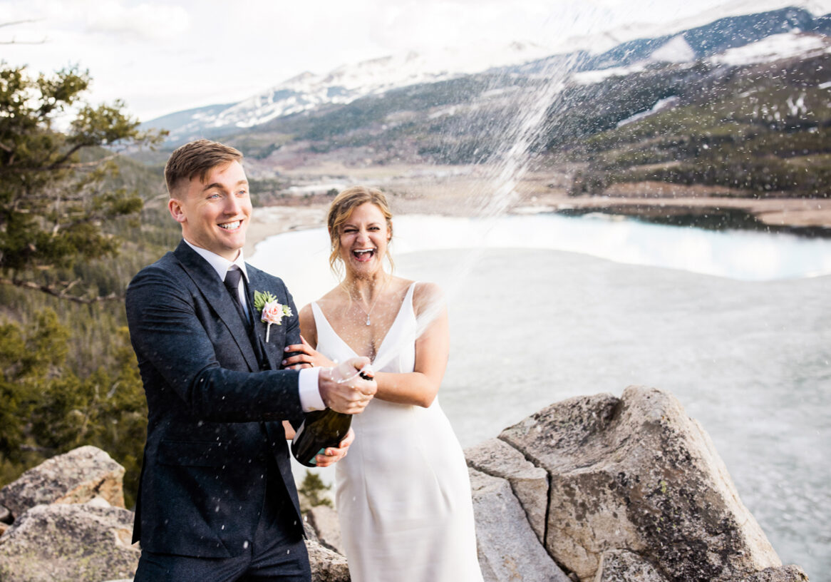 couple spraying champagne after elopement